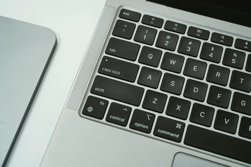 白いデスクに置かれたシルバーのノートPCとタブレット